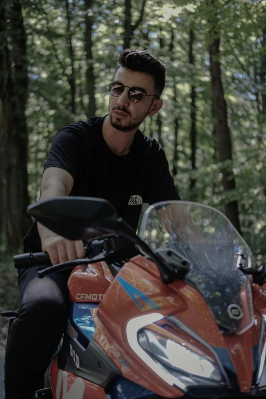 a man is riding an orange motorcycle through the woods