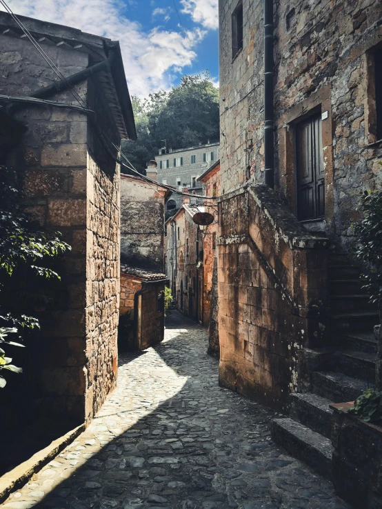 a narrow stone street between buildings and cobblestone