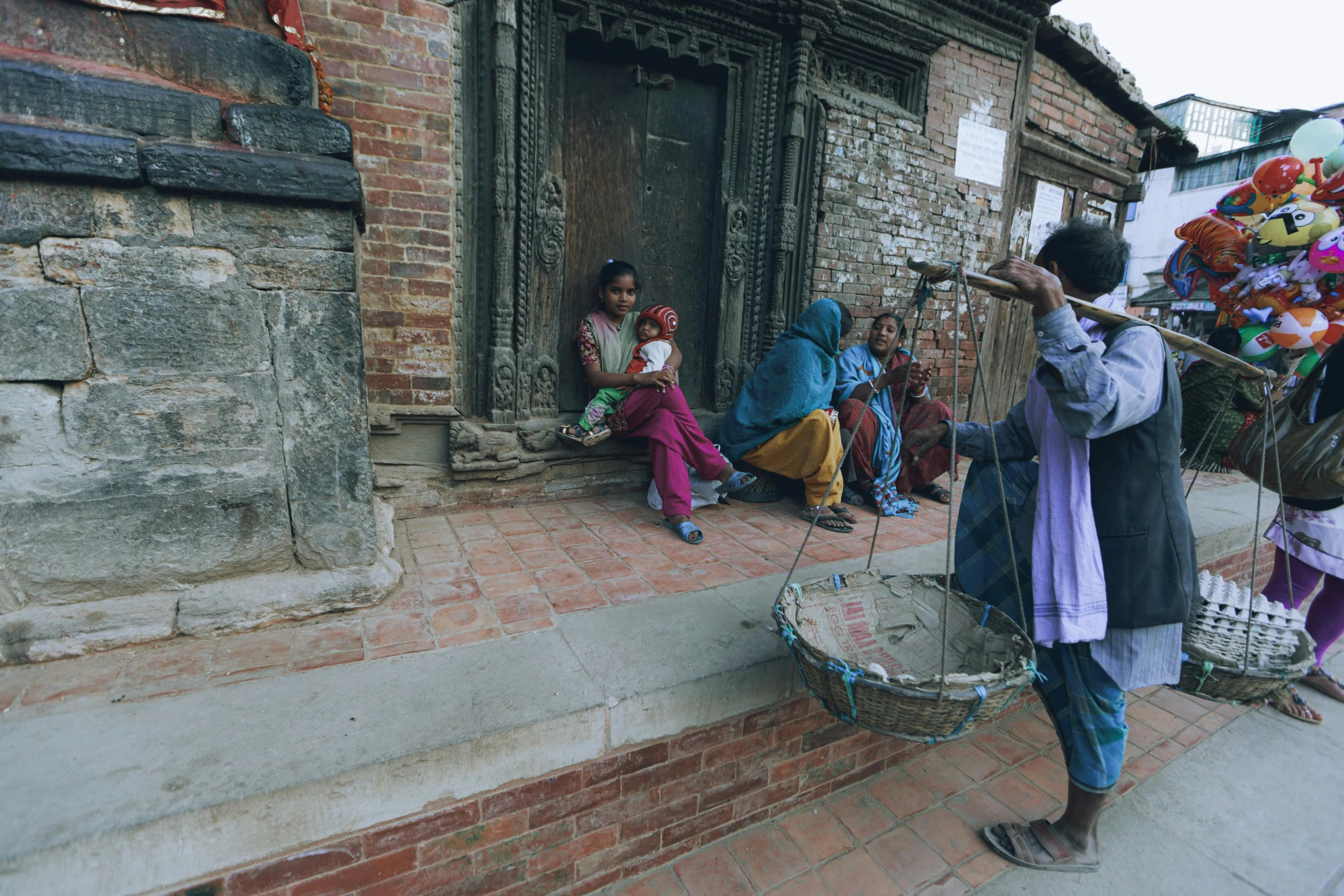 men sitting on the steps playing instruments with some people seated down outside