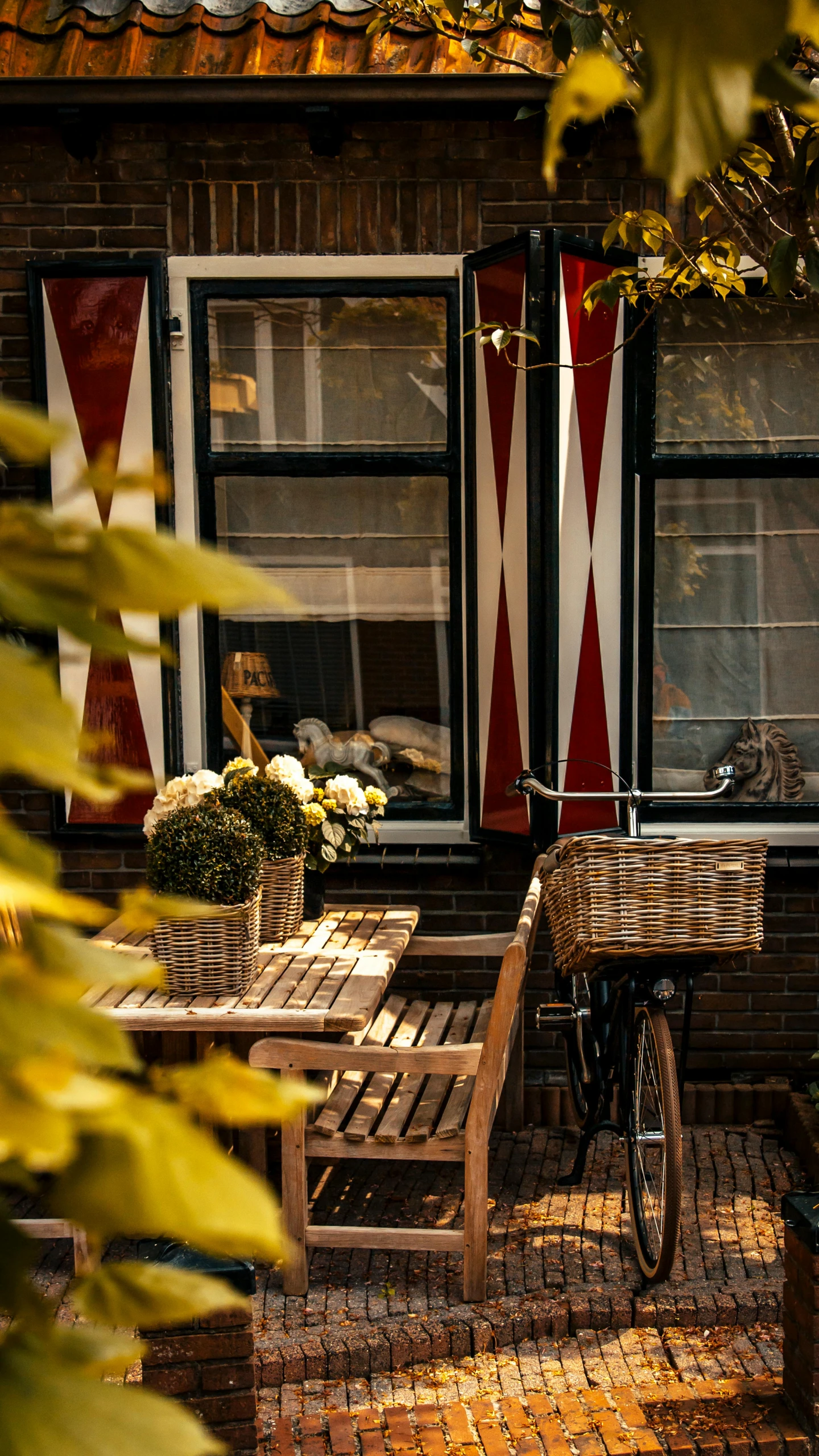 a wooden table and chairs sitting outside of a building