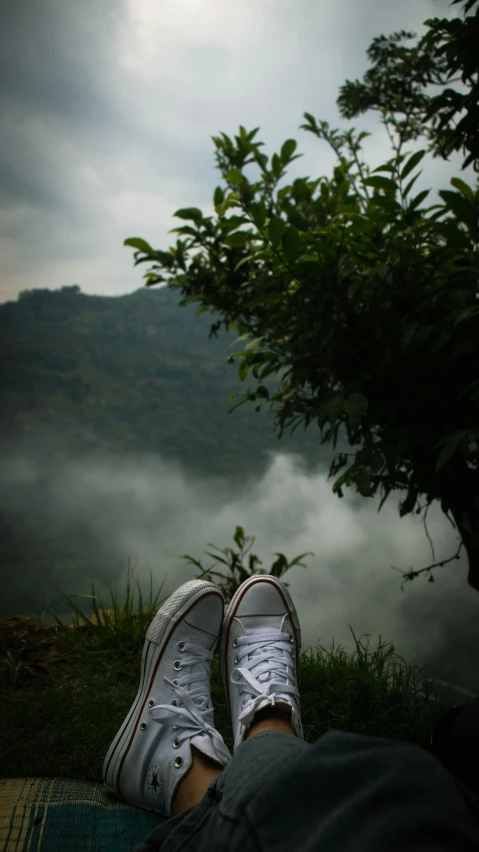 a pair of feet propped up on a mat and a lake filled with fog