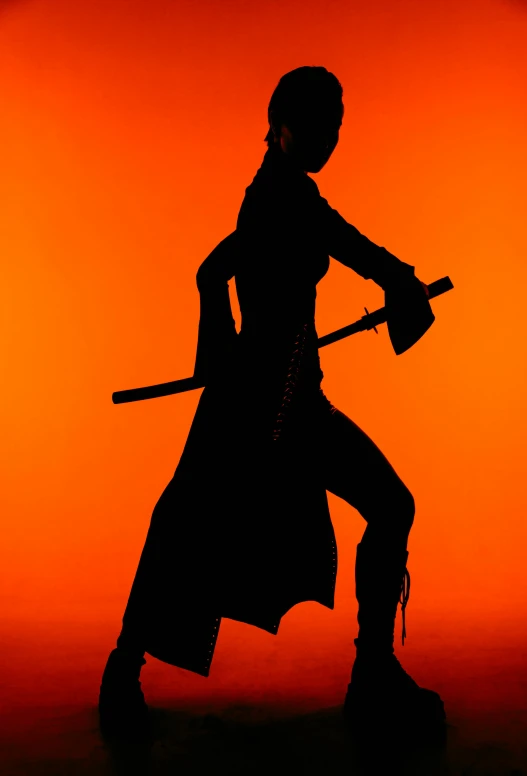 the silhouette is of a female figure holding a broom and a hat