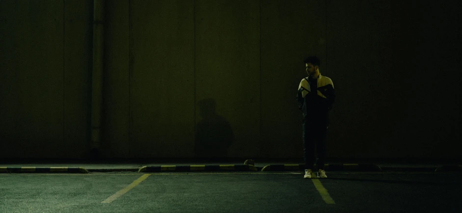 a person standing in a dimly lit parking lot