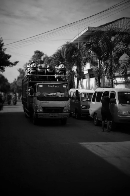 a very crowded city street with several parked vehicles and people