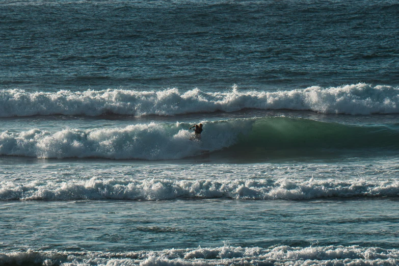 a person rides a surfboard on top of waves