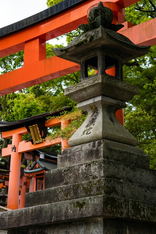a small shrine with tall, orange columns near trees