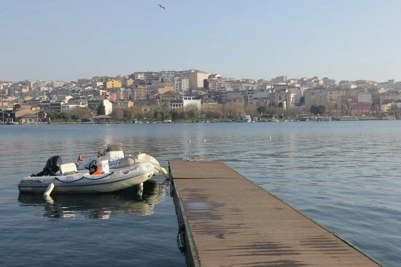 some small motor boats on a lake next to a pier