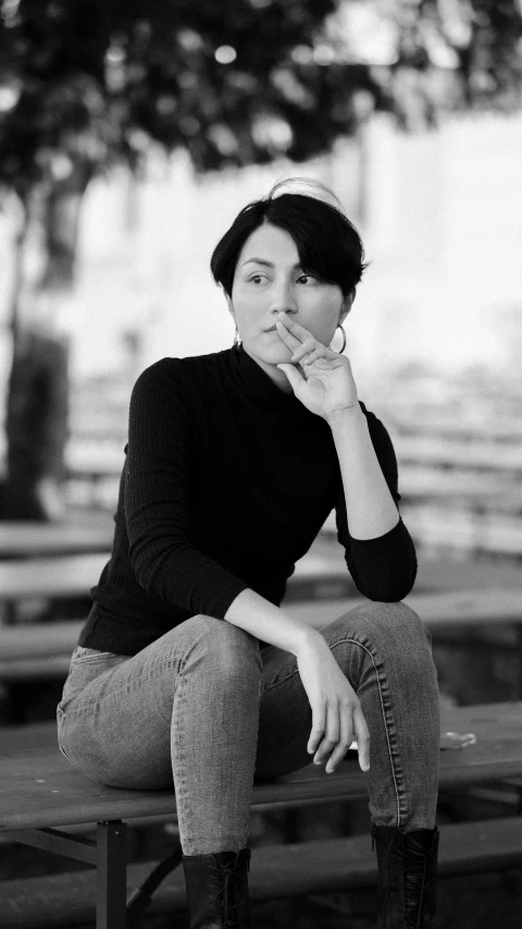 a black and white po of a woman sitting on a bench