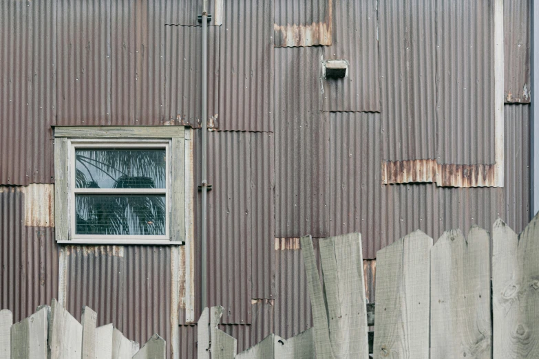 a barn with brown metal and broken down siding