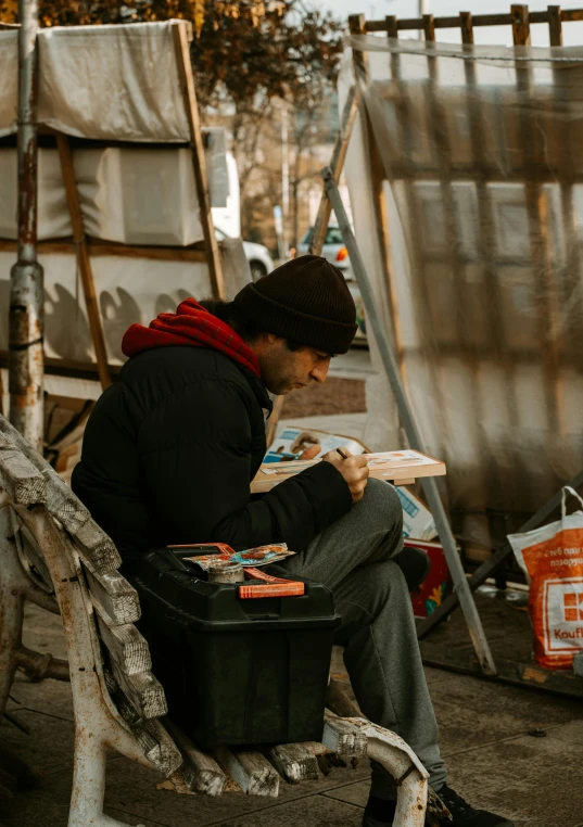 a person sitting on a bench reading a book