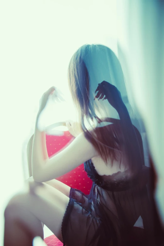 a woman sitting on a red chair in a dark room