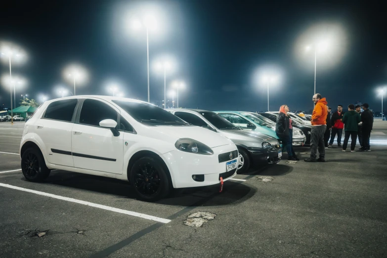 white cars are in a parking lot with bright lights