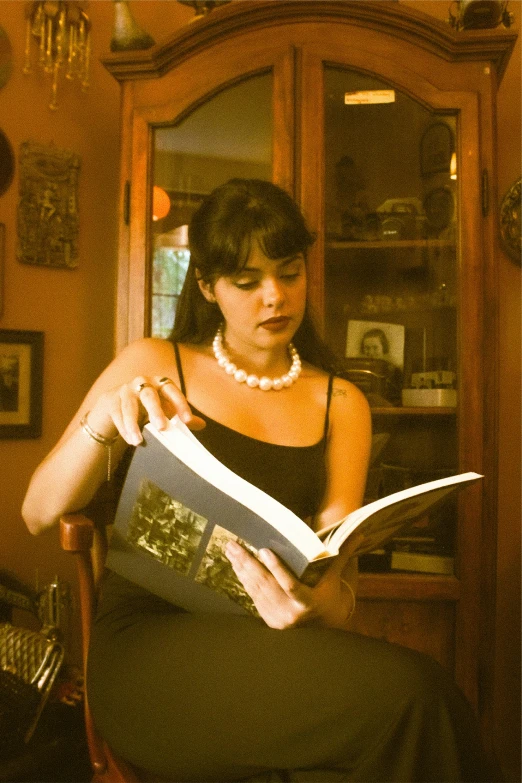 a woman is sitting down reading a book