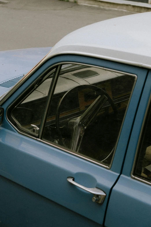 an old blue car with the top window open