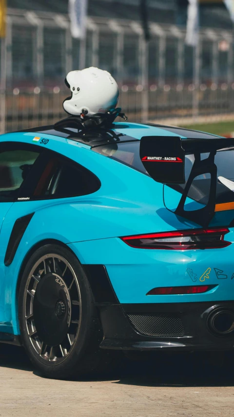 a blue sports car with a white and black helmet on top