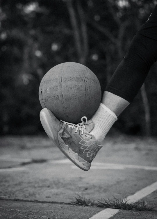 a basketball is held in one hand and a person is on another