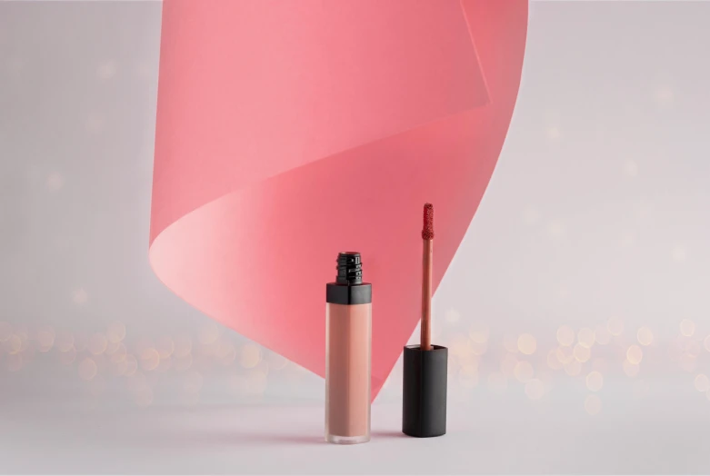 a pink shade on a wall and two tubes for the cosmetics