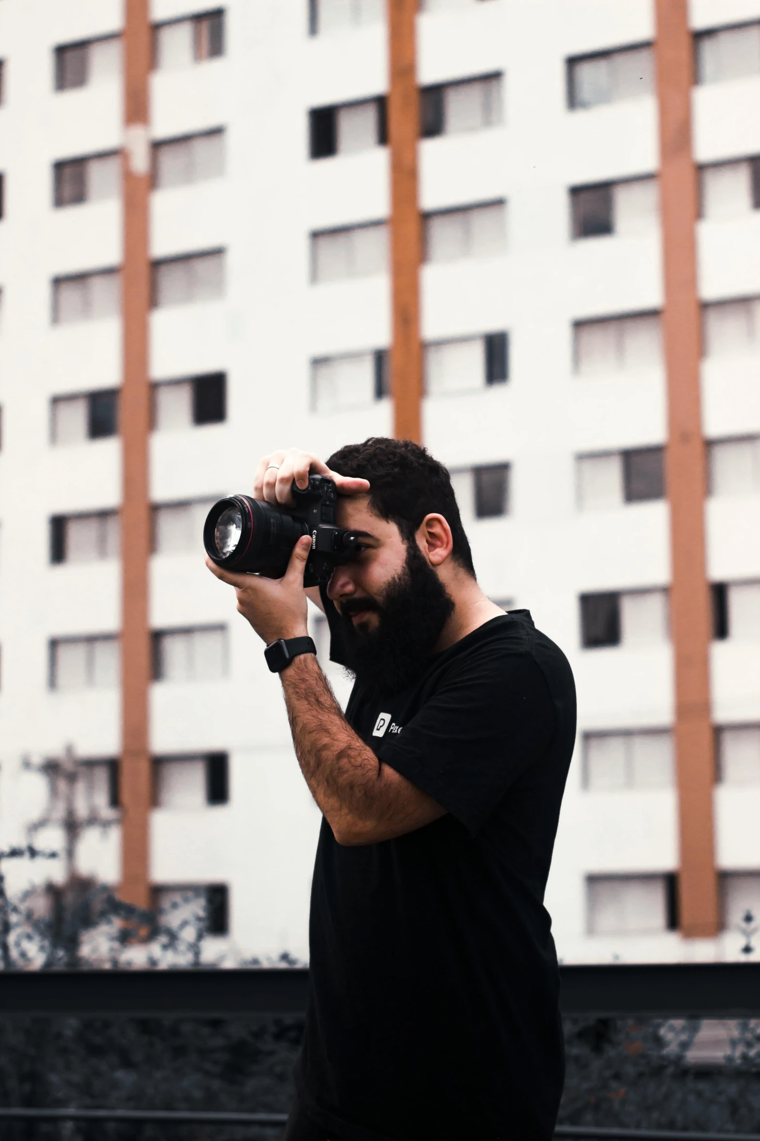 a man with a beard takes pictures with his camera