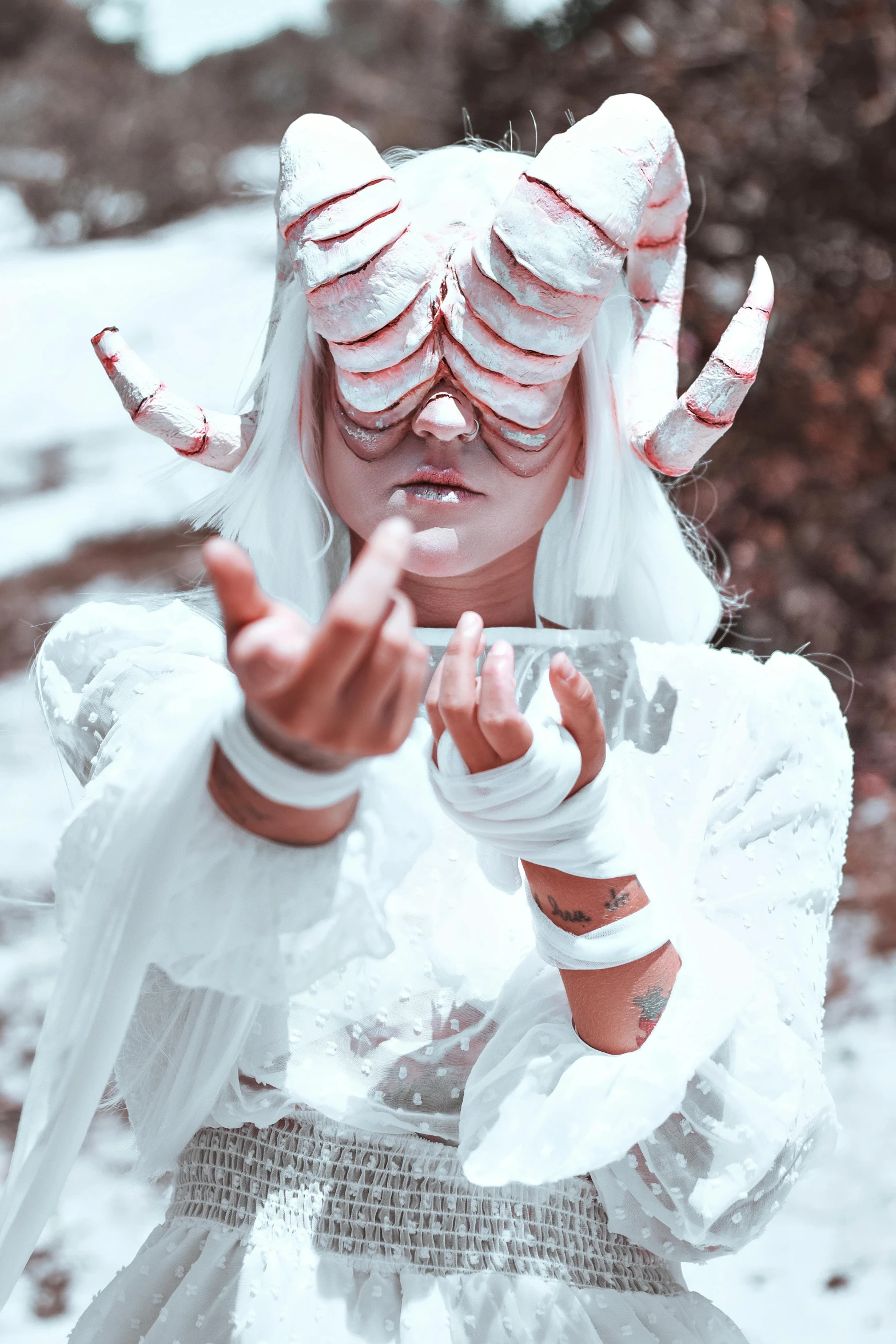 a woman in white is holding her hands up