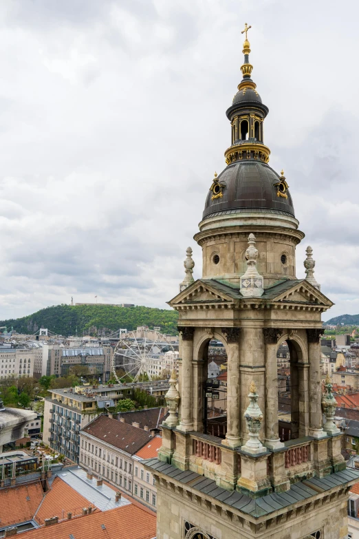 a tower with a cross is in the foreground of the view