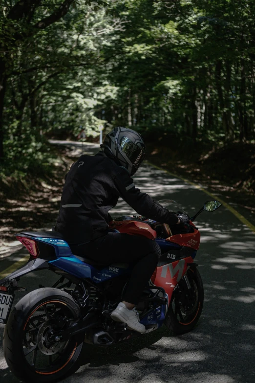 a man riding on the back of a red motorcycle