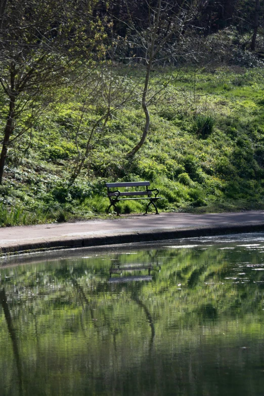 the reflection of a bench is in a lake