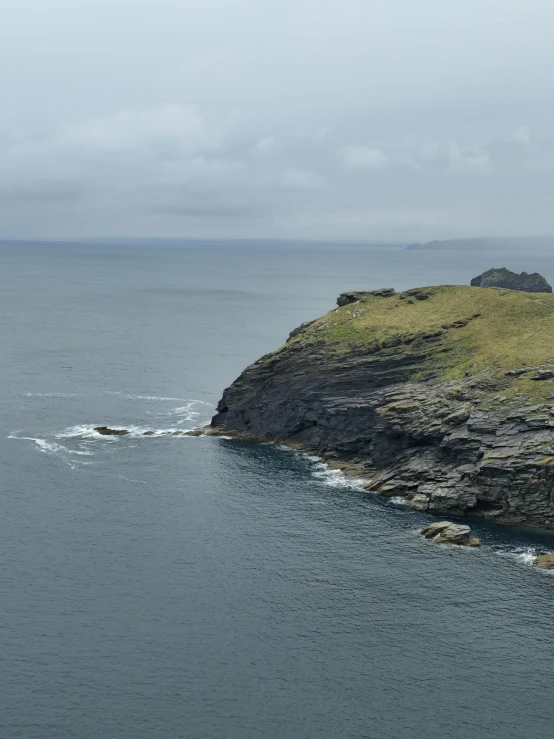 lighthouse along coastline against cloudy sky near ocean