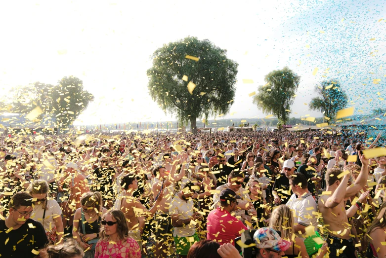 several people standing outside with balloons and confetti thrown in the air