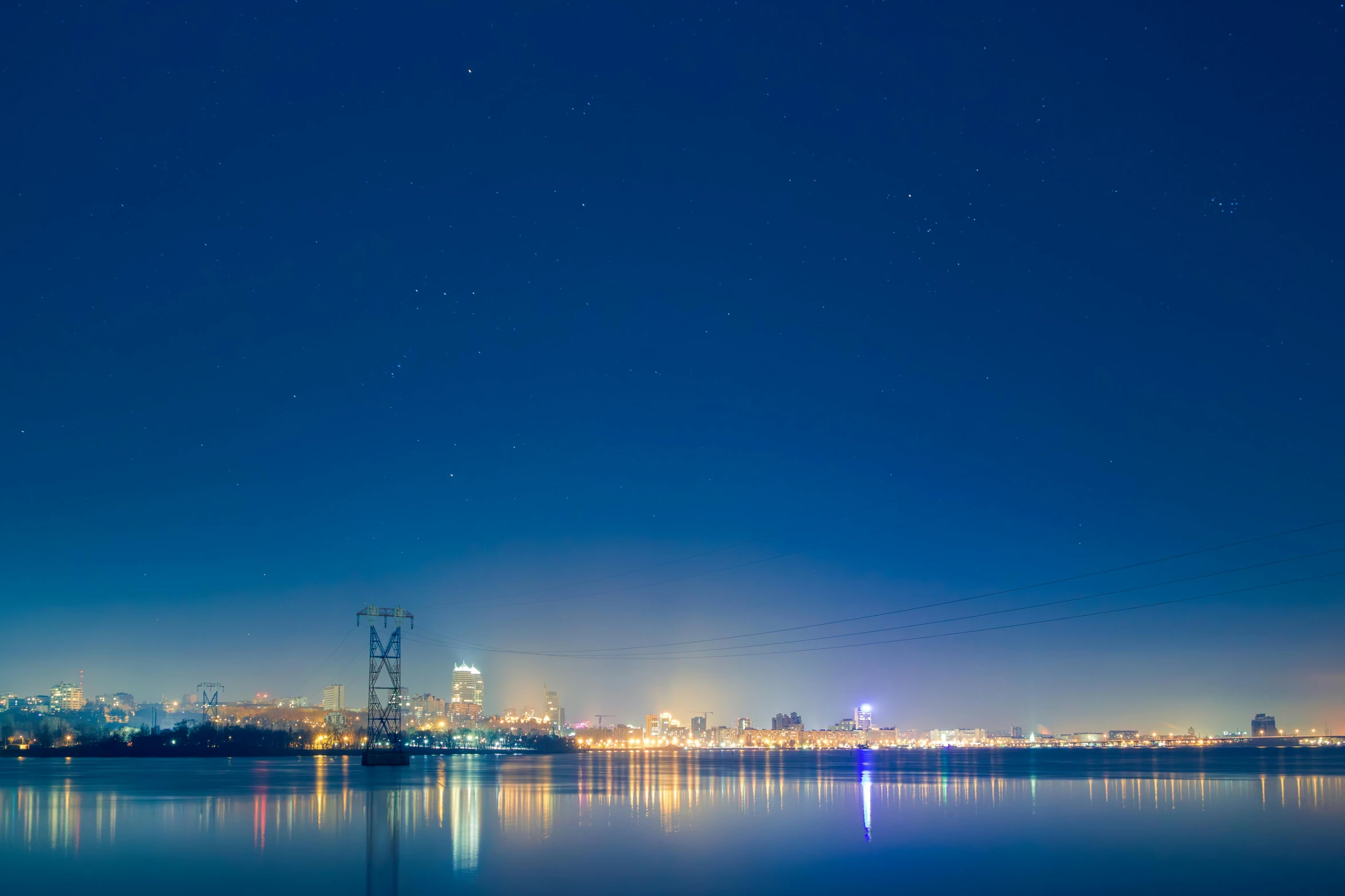 city skyline at night, reflecting on still water