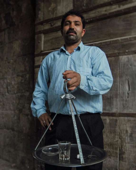 a man standing with a glass display holding scissors