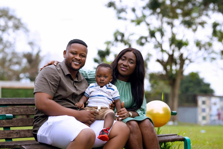 a family poses on a bench for a po