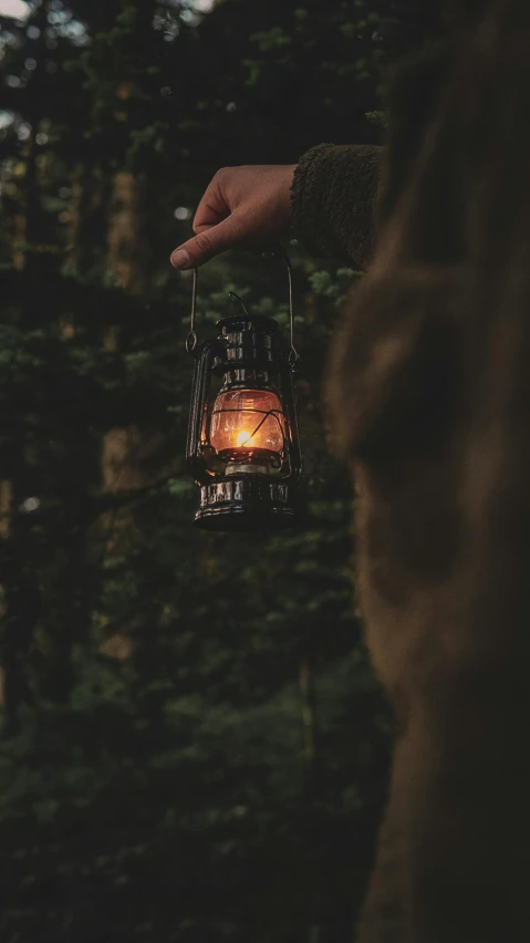 a lit candle in a wire cage hanging from the side