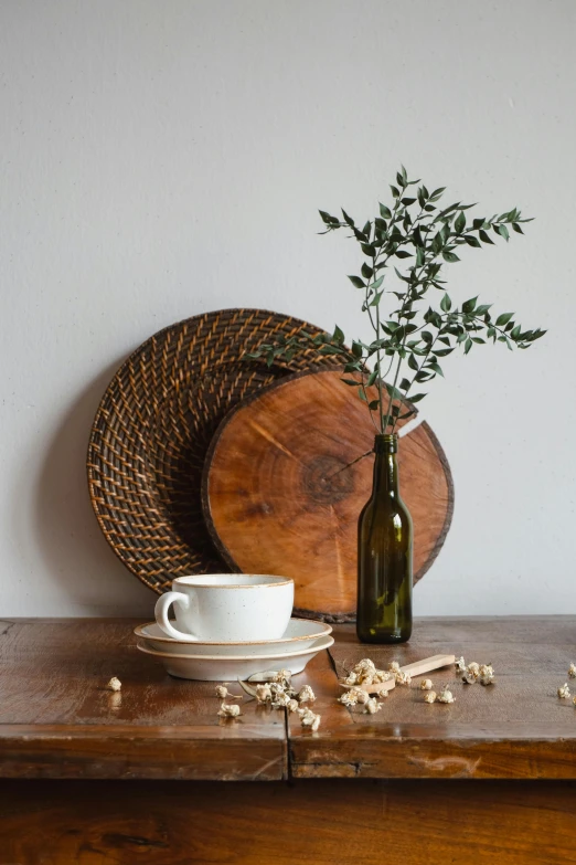 a table topped with a vase filled with greenery