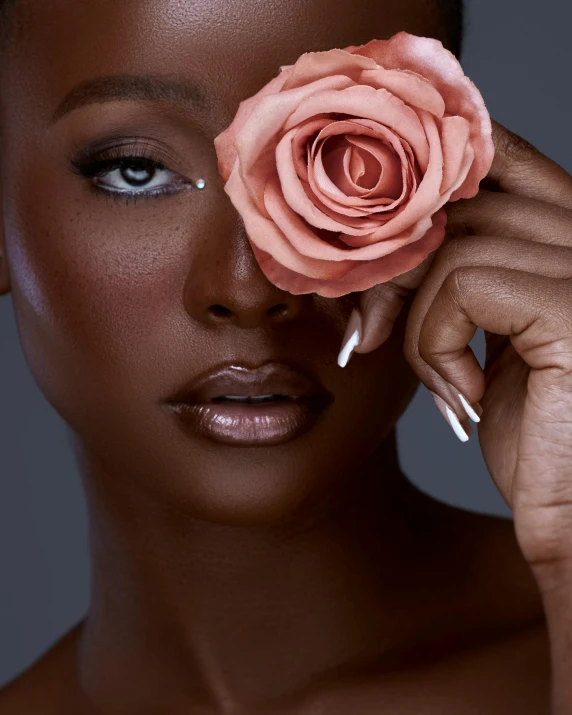 a beautiful woman holding a pink rose against her eye