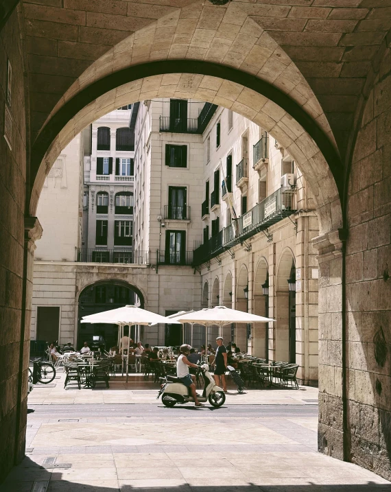 a courtyard with chairs and tables has umbrellas