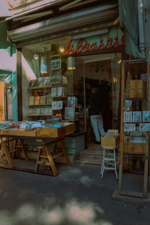a bookshop with an outside sign and tables