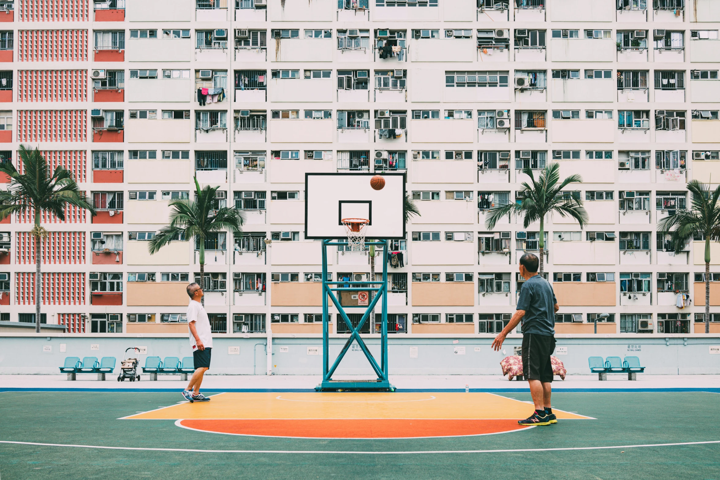 a man playing basketball in front of a building