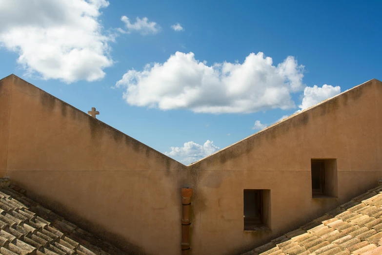 two concrete structures with a cloudy blue sky in the background