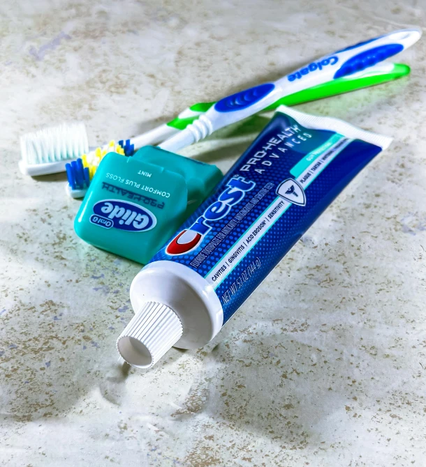 two toothbrushes and tube on the counter