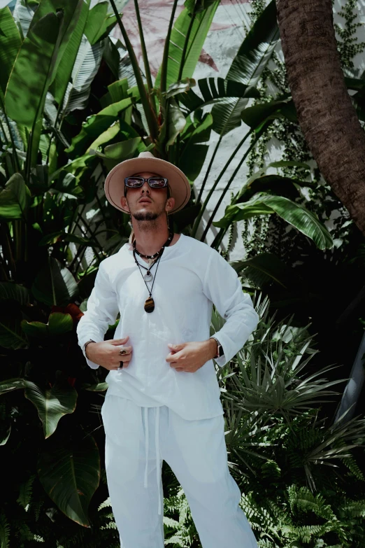 a man is wearing white while standing near some trees