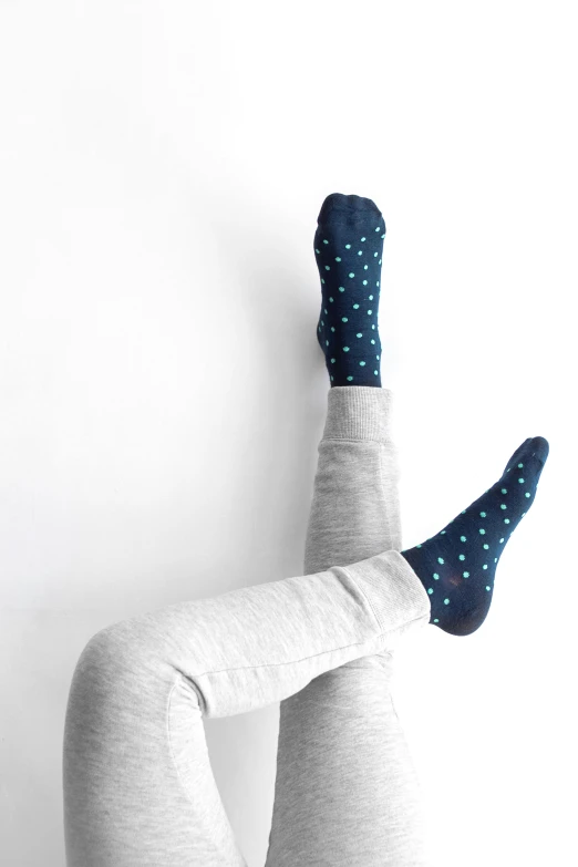 a woman with her legs up and her leg in a sweater with dots