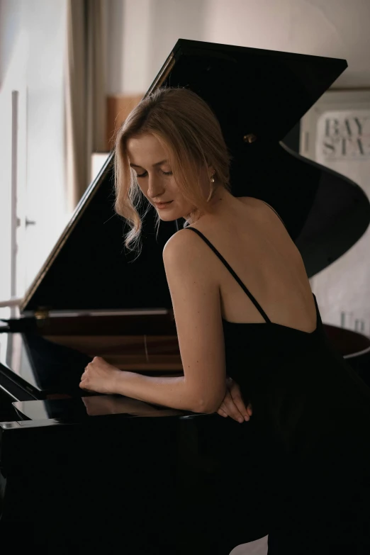 an image of woman in black dress playing piano