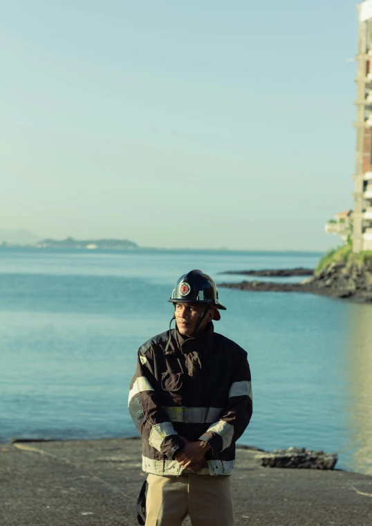 a man wearing a hard hat while standing next to the ocean