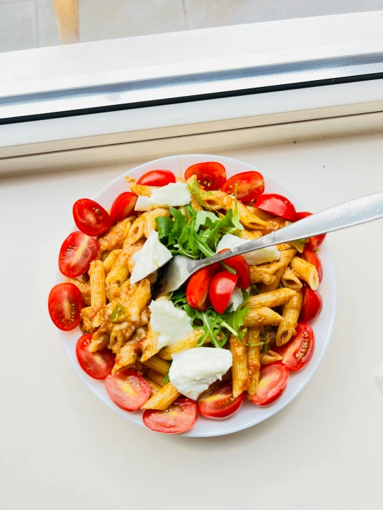 a plate filled with pasta salad and vegetables