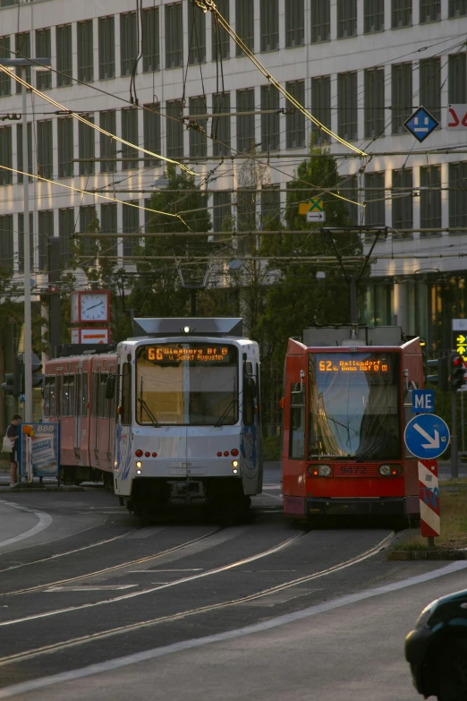 two red and white buses are driving in opposite directions