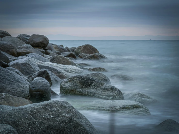 a beach with large rocks covered in water