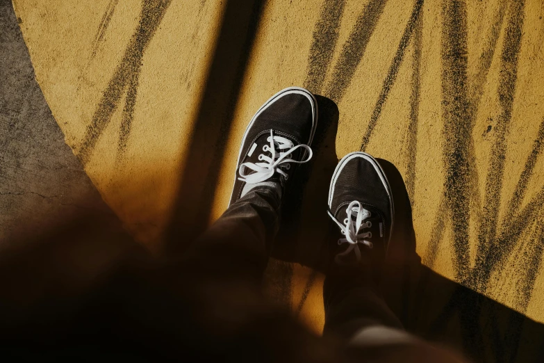 person with black and white sneakers in front of a yellow blanket