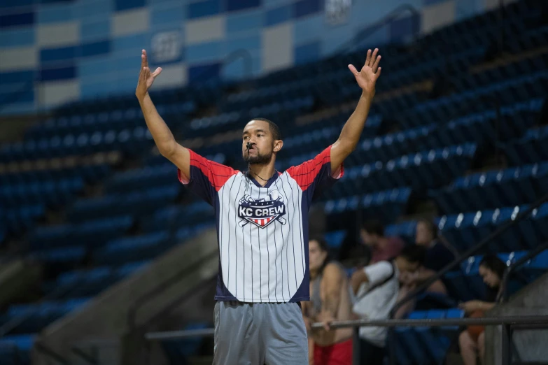 a man in a jersey holds his arms up