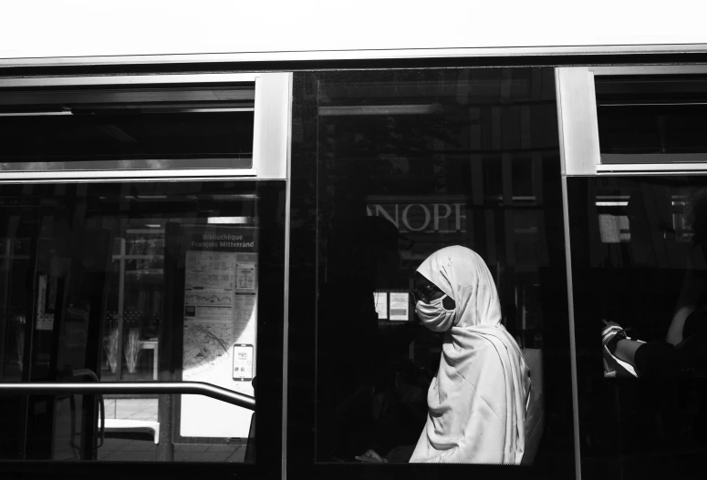 a nun in front of the bus window with an umbrella