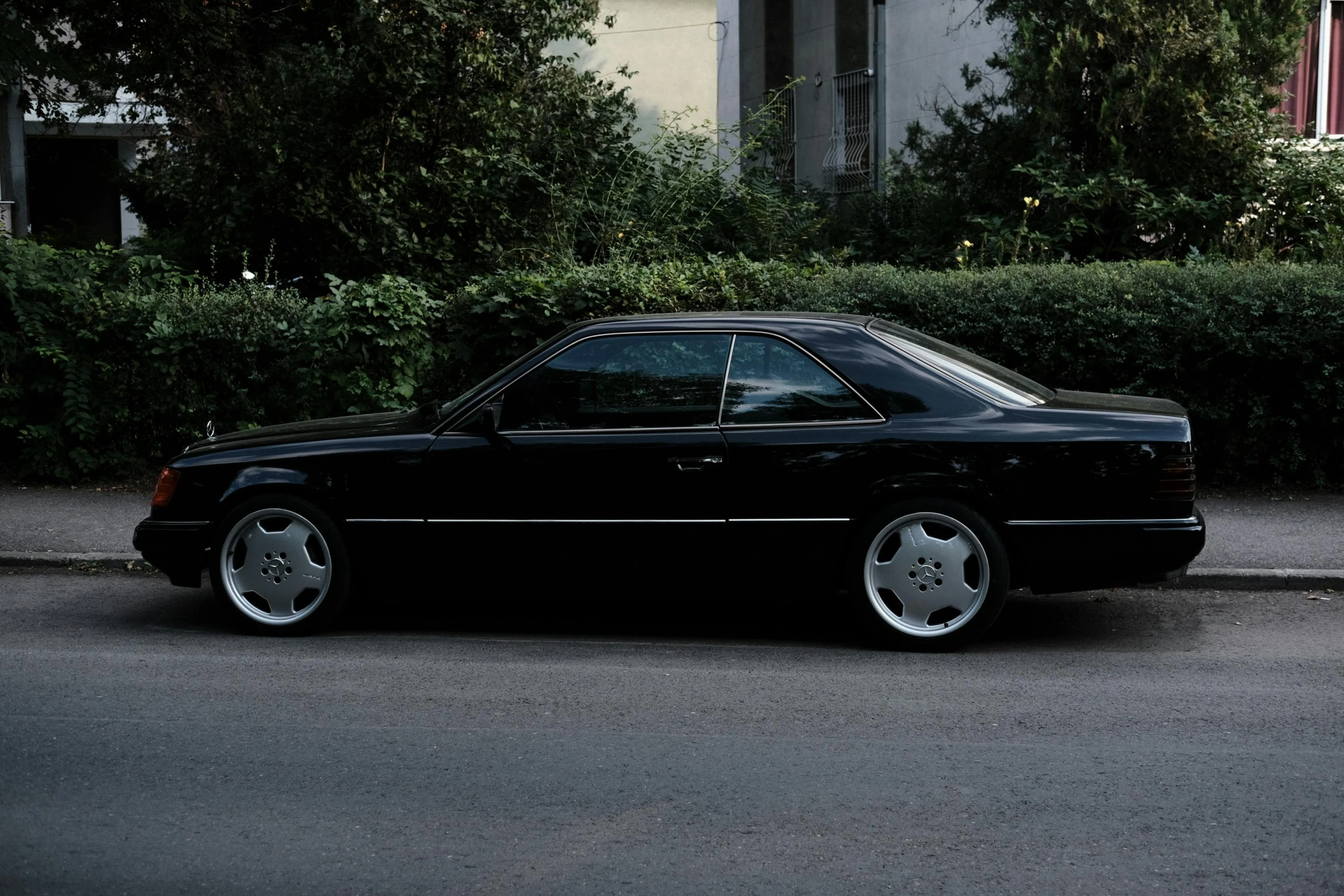 a black mercedes is parked on the street